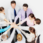 Business people in circle stacking hands